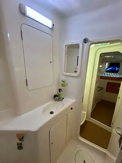 Hazey Daze Yacht Photos Pics 2001 Voyage Maxim yacht bathroom with sink, mirror, and storage compartments.