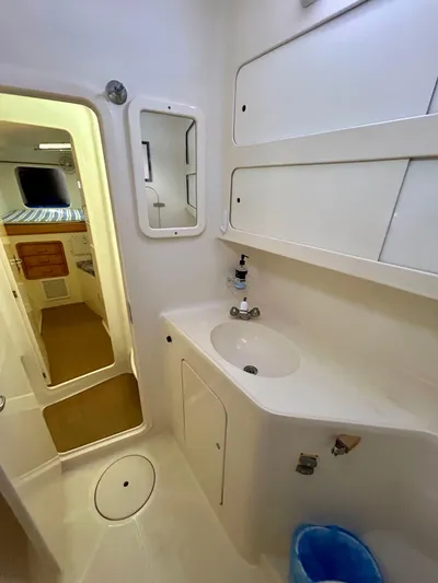Hazey Daze Yacht Photos Pics Compact bathroom in 2001 Voyage Maxim yacht with sink, mirror, and storage.