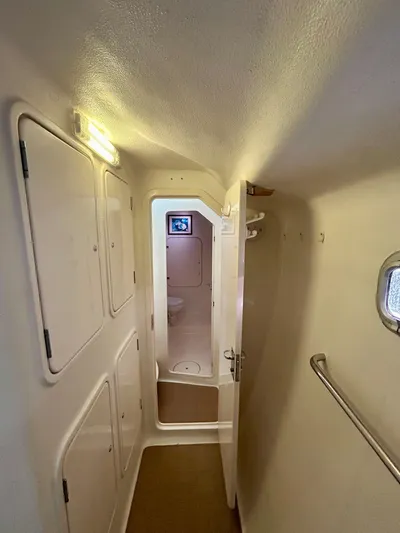 Hazey Daze Yacht Photos Pics Narrow hallway inside 2001 Voyage Maxim boat, featuring storage compartments and a small window.