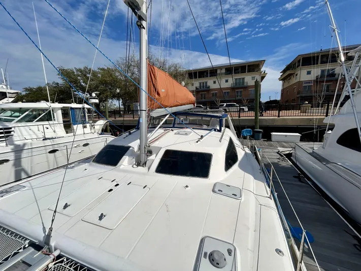 Hazey Daze Yacht Photos Pics Sailboat docked at marina, Voyage Maxim 2001 model, with orange sail and clear sky.
