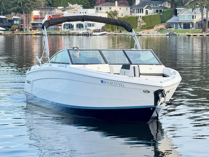  Yacht Photos Pics 2023 Cobalt R8 boat cruising on a calm lake near waterfront homes.