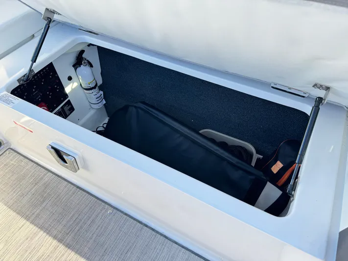  Yacht Photos Pics Storage compartment in 2023 Cobalt R8 boat, featuring organized interior and safety equipment.