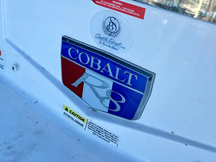  Yacht Photos Pics Cobalt R8 2023 model emblem on a white boat surface with caution labels.
