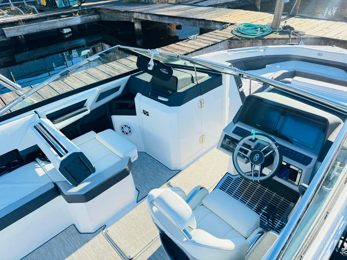  Yacht Photos Pics 2023 Cobalt R8 boat interior with modern dashboard and seating at a dock.