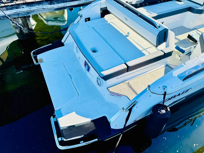  Yacht Photos Pics 2023 Cobalt R8 boat with spacious seating and swim platform, docked on calm water.