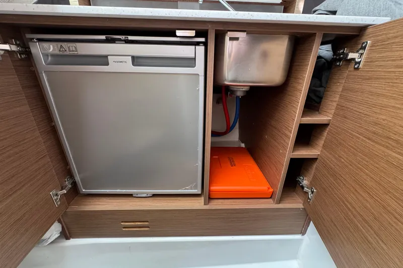  Yacht Photos Pics 2021 Jeanneau Leader 9.0 WA interior showing fridge, sink, and storage compartments.