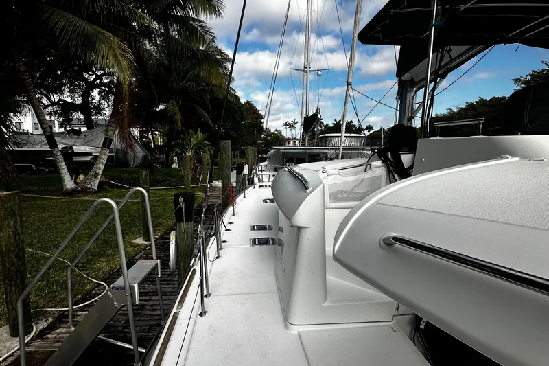 Cruisin Cajun Yacht Photos Pics 2017 Lagoon 450 F catamaran docked, surrounded by lush greenery and palm trees.