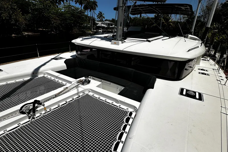 Cruisin Cajun Yacht Photos Pics 2017 Lagoon 450 F catamaran deck with netting, docked near palm trees.