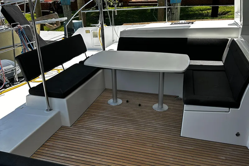 Cruisin Cajun Yacht Photos Pics Outdoor seating area on 2017 Lagoon 450 F catamaran with wooden deck and cushioned benches.