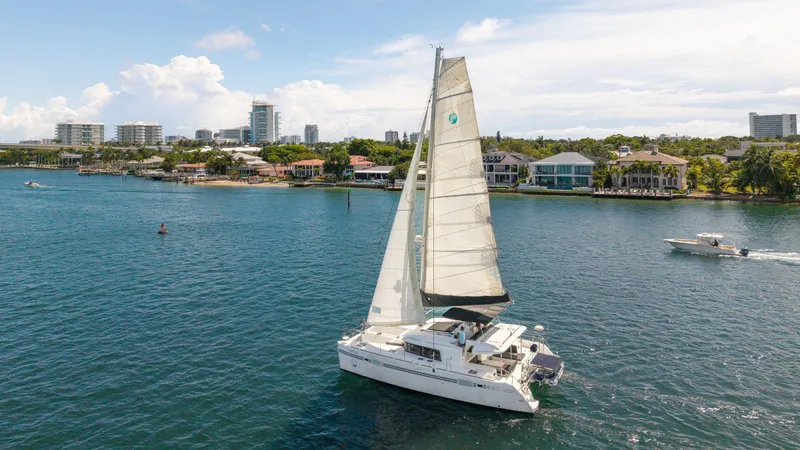 Cruisin Cajun Yacht Photos Pics 2017 Lagoon 450 F catamaran sailing near coastal cityscape.
