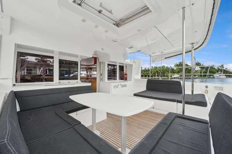 Cruisin Cajun Yacht Photos Pics 2017 Lagoon 450 F yacht interior with spacious seating and table, overlooking serene waterfront.