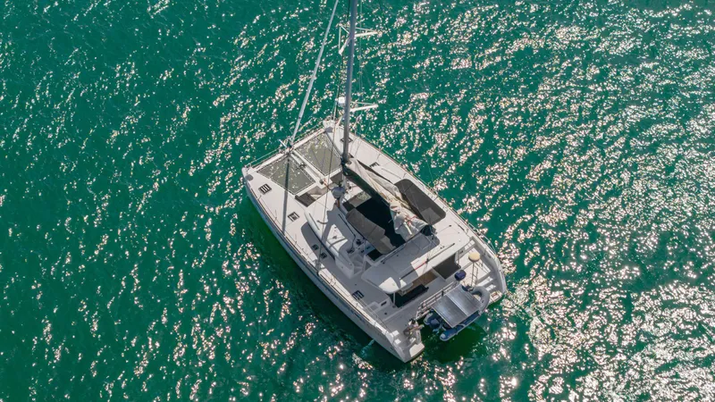 Cruisin Cajun Yacht Photos Pics Aerial view of 2017 Lagoon 450 F catamaran sailing on sparkling turquoise water.