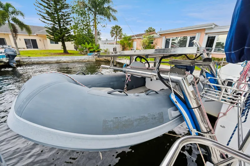 Cruisin Cajun Yacht Photos Pics Inflatable dinghy on Lagoon 450 F catamaran, docked near waterfront homes, 2017 model.