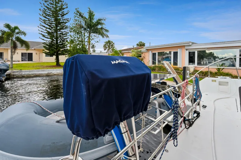 Cruisin Cajun Yacht Photos Pics Lagoon 450 F 2017 yacht with covered equipment, docked near waterfront homes.