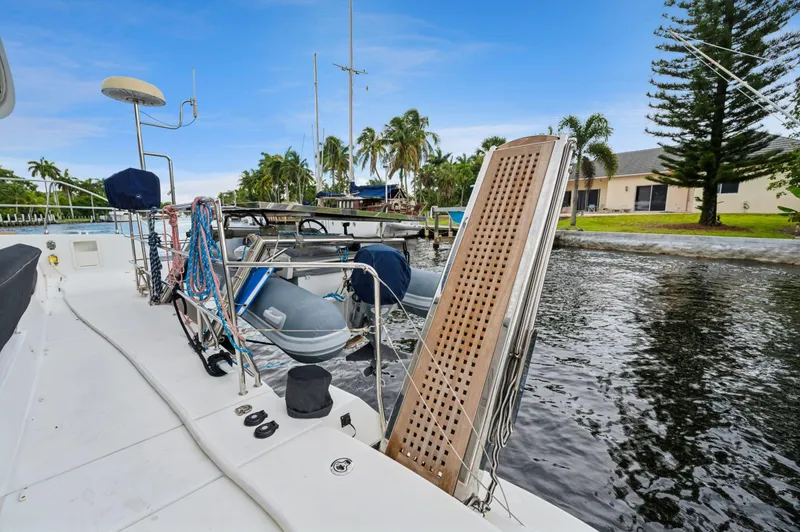 Cruisin Cajun Yacht Photos Pics 2017 Lagoon 450 F catamaran docked by a canal with lush greenery.