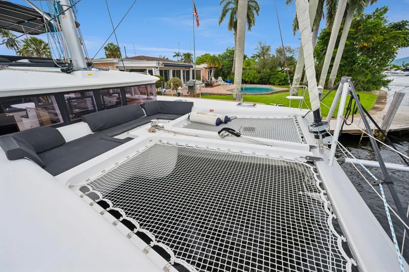 Cruisin Cajun Yacht Photos Pics 2017 Lagoon 450 F catamaran with spacious deck and netting, docked near a tropical waterfront home.