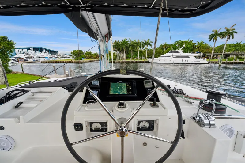 Cruisin Cajun Yacht Photos Pics Helm of 2017 Lagoon 450 F catamaran with marina view and palm trees.