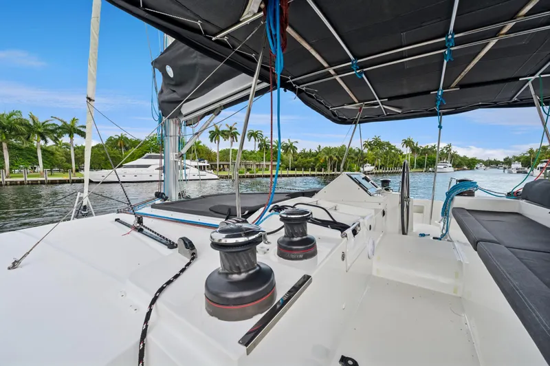 Cruisin Cajun Yacht Photos Pics 2017 Lagoon 450 F catamaran deck with winches and seating, docked near palm trees.