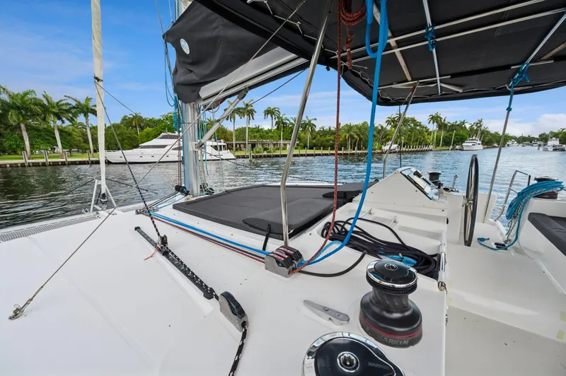 Cruisin Cajun Yacht Photos Pics 2017 Lagoon 450 F catamaran deck with ropes and steering wheel, docked by palm trees.