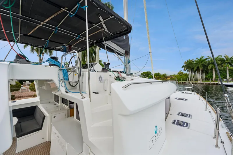 Cruisin Cajun Yacht Photos Pics 2017 Lagoon 450 F catamaran docked, featuring spacious deck and helm, surrounded by palm trees.