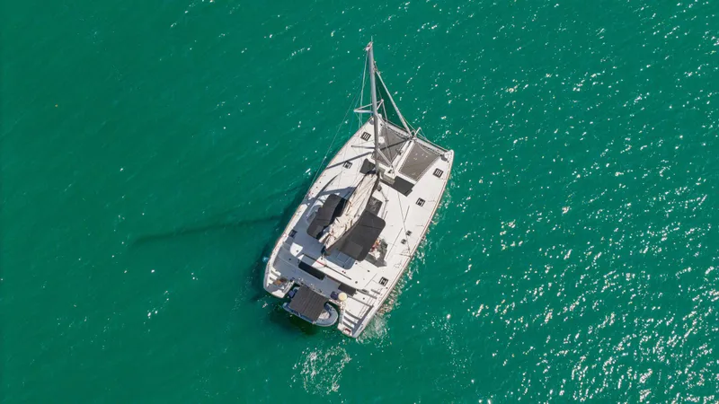 Cruisin Cajun Yacht Photos Pics Aerial view of 2017 Lagoon 450 F catamaran sailing on turquoise water.