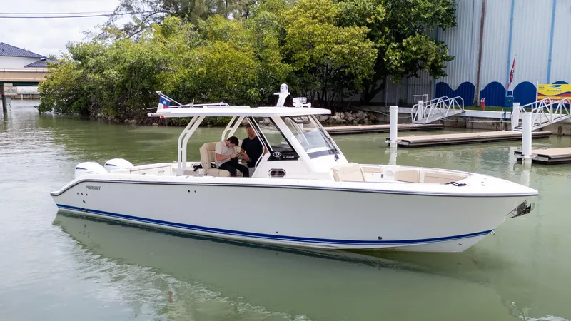 Burnin' Daylight Yacht Photos Pics 2018 Pursuit S 328 boat docked in a marina, surrounded by greenery.