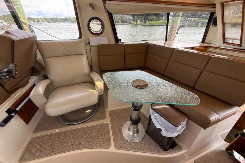 Yacht Photos Pics Interior of 2021 Ranger Tugs R-41CB with leather seating and glass table, overlooking water.