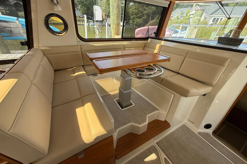  Yacht Photos Pics Interior of 2021 Ranger Tugs R-41CB with beige seating and wooden table.