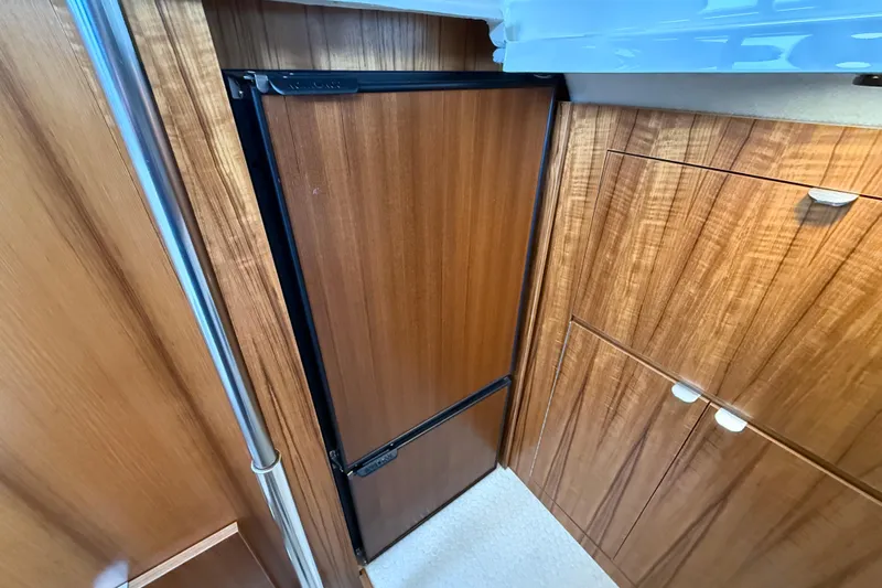  Yacht Photos Pics 2021 Ranger Tugs R-41CB interior with wood cabinetry and compact refrigerator.