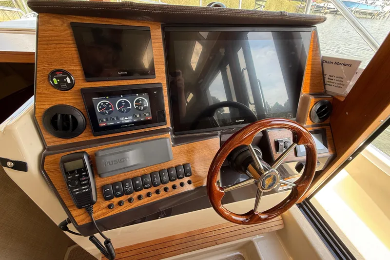  Yacht Photos Pics 2021 Ranger Tugs R-41CB helm with wooden steering wheel and modern navigation displays.