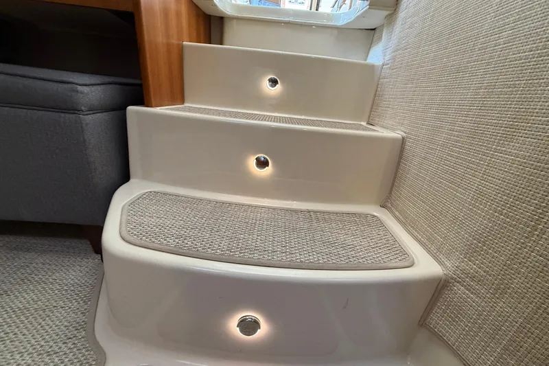  Yacht Photos Pics Illuminated interior steps on 2021 Ranger Tugs R-41CB boat, featuring carpeted treads.