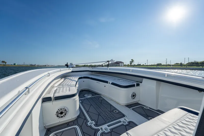  Yacht Photos Pics 2021 Yellowfin 32 Offshore boat interior with cushioned seating and sunny sky.