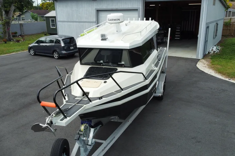  Yacht Photos Pics 2024 Sea King 260 boat on trailer, parked outside a garage.