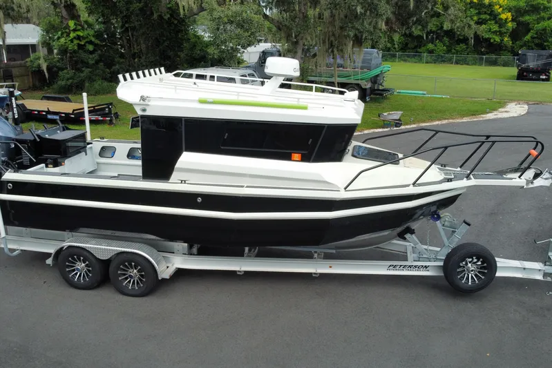  Yacht Photos Pics 2024 Sea King 260 boat on trailer, parked outdoors, showcasing sleek design and modern features.