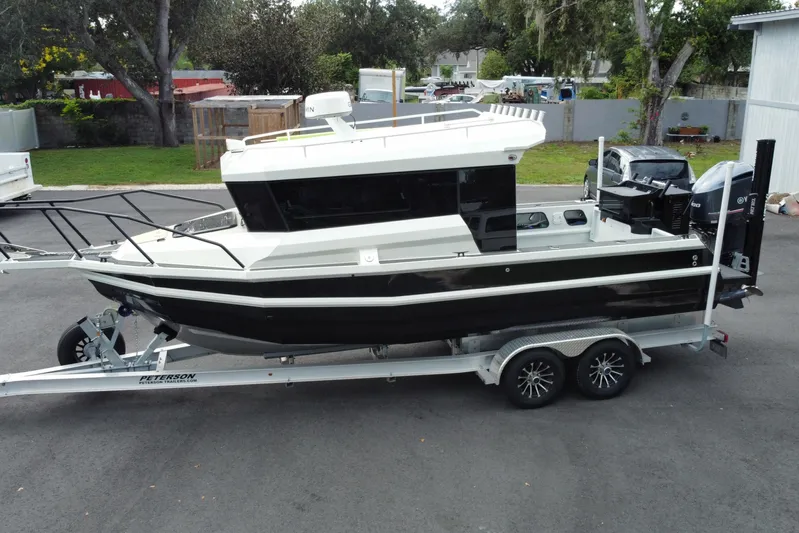 Yacht Photos Pics 2024 Sea King 260 boat on trailer, parked outdoors, side view.