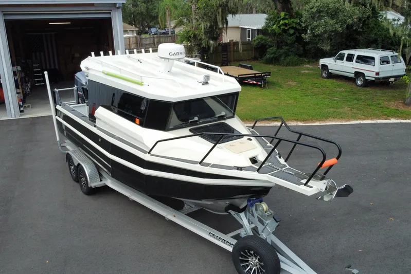  Yacht Photos Pics 2024 Sea King 260 boat on trailer, parked outside a garage.