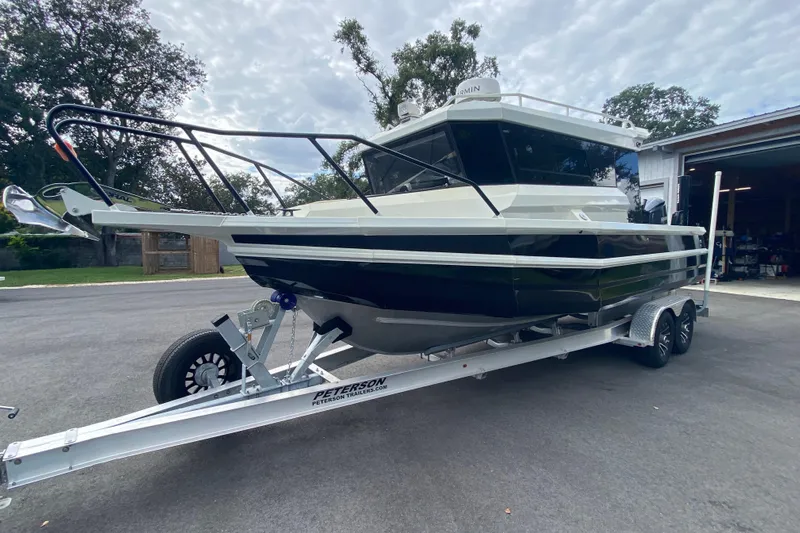  Yacht Photos Pics 2024 Sea King 260 boat on trailer, parked outdoors near a garage.