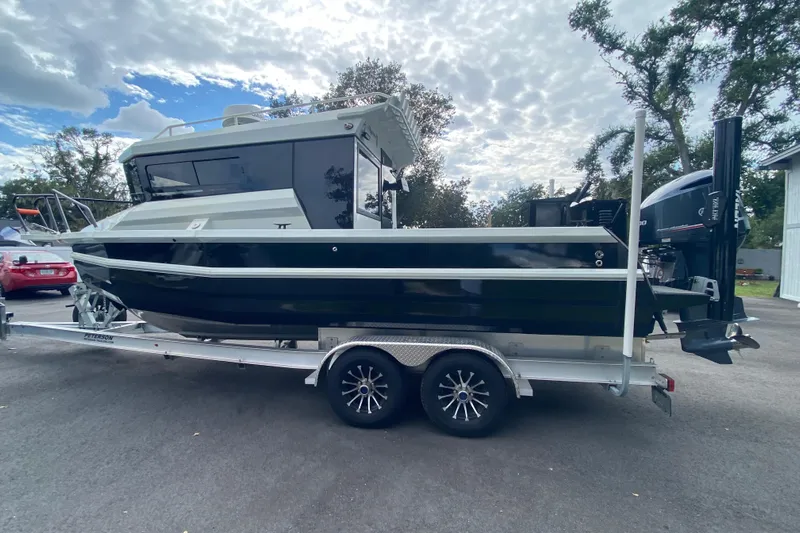  Yacht Photos Pics 2024 Sea King 260 boat on trailer, parked outdoors under cloudy sky.