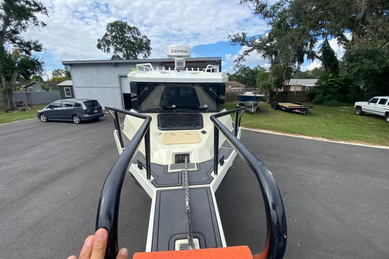  Yacht Photos Pics 2024 Sea King 260 boat on trailer, parked outdoors with trees and vehicles nearby.