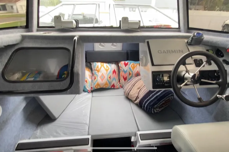  Yacht Photos Pics 2024 Sea King 260 boat interior with Garmin navigation, cozy seating, and colorful cushions.