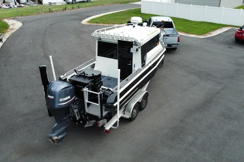 Yacht Photos Pics 2024 Sea King 260 boat on trailer, equipped with Yamaha 300 engine, parked on asphalt.