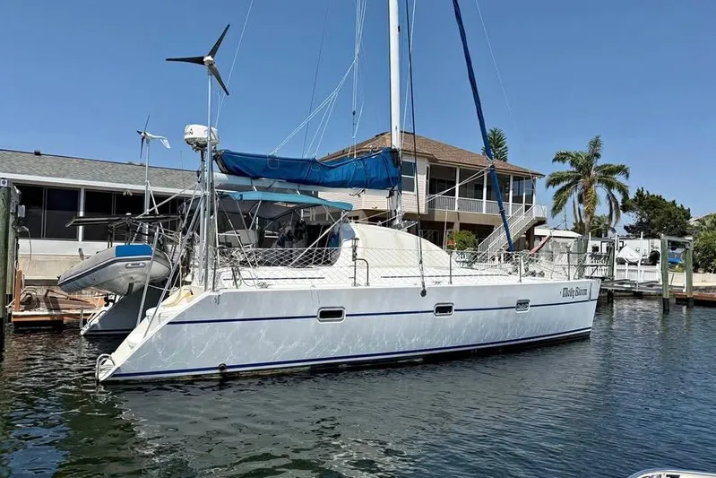  Yacht Photos Pics 1993 Jeanneau Lagoon 37 TPI Catamaran docked near waterfront home.