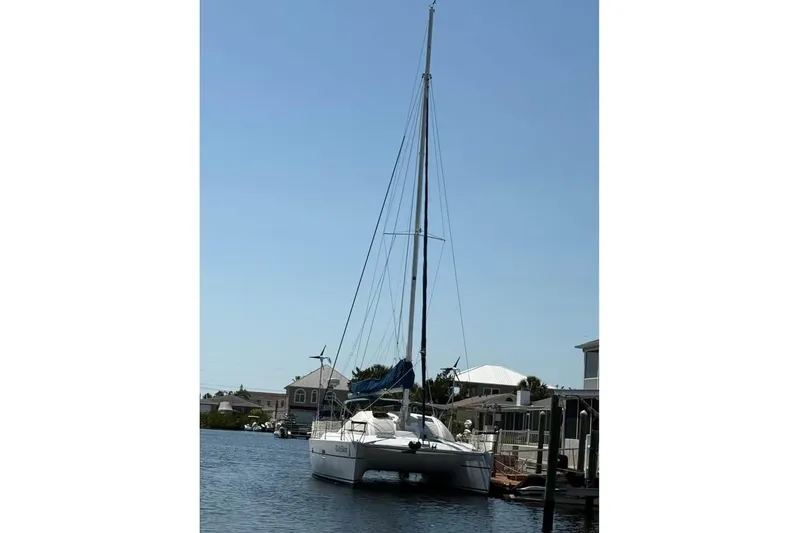  Yacht Photos Pics 1993 Jeanneau Lagoon 37 TPI Catamaran docked in a serene marina setting.
