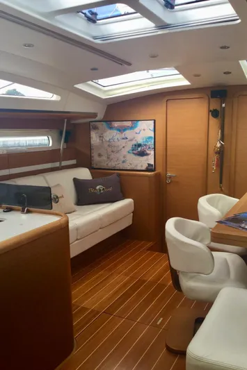 My Black Pearl Yacht Photos Pics Luxurious interior of a 2015 Jeanneau 57 yacht with elegant seating and wooden flooring.