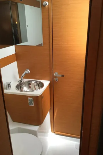 My Black Pearl Yacht Photos Pics 2015 Jeanneau 57 yacht bathroom with modern sink and wooden cabinetry.