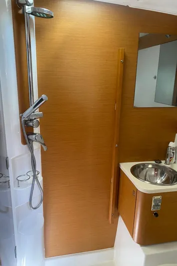 My Black Pearl Yacht Photos Pics 2015 Jeanneau 57 yacht bathroom with shower, sink, and wooden paneling.