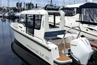 2023 Nimbus Commuter 8 boat docked in marina, featuring Mercury outboard engine.
