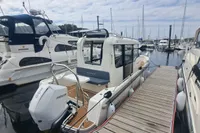 2023 Nimbus Commuter 8 boat docked at marina, surrounded by other vessels.