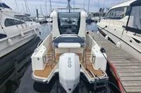 2023 Nimbus Commuter 8 boat docked at marina, surrounded by other vessels.