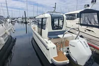 2023 Nimbus Commuter 8 boat docked at marina, featuring Mercury outboard engine.